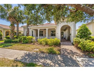 Charming home featuring a welcoming front porch, arched entryway, and beautifully landscaped front yard at 1520 Dorgali Dr, Sarasota, FL 34238