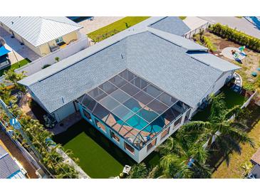 Aerial view of a home featuring a screened-in pool area, spacious yard, and lush tropical landscaping at 1724 Cheyenne St, Sarasota, FL 34231