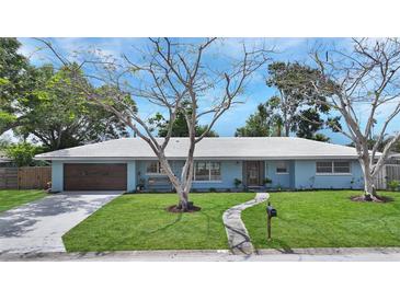 Charming one story home with beautiful yard, light blue exterior, and mature trees at 2932 Upper Tangelo Dr, Sarasota, FL 34239