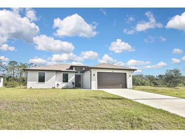 Charming single-story home with a well-manicured lawn and a two-car garage at 3836 Wenona Dr, North Port, FL 34288