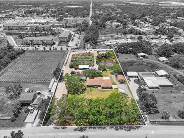 Aerial view of the property with mature landscaping and a pond at 5024 37Th E St, Bradenton, FL 34203