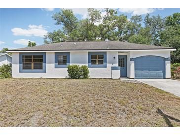 Charming single-story home with blue trim, attached garage, and a cozy front yard at 5414 Ansonia Ter, North Port, FL 34287