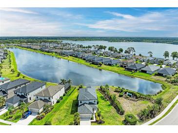 Stunning aerial view of homes along a tranquil lake, showcasing community and water views at 5583 Summit Gln, Bradenton, FL 34203