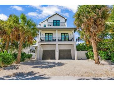 Beautiful beach home featuring a two-car garage and multiple levels of covered balconies at 89 Avenida Messina, Sarasota, FL 34242