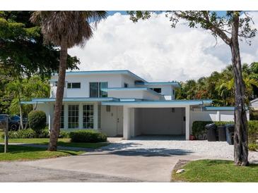 Charming two-story home with well-maintained landscaping, a carport, and a concrete driveway at 91 Avenida Veneccia, Sarasota, FL 34242