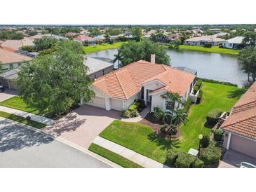 Beautiful single Gathering home with a terracotta roof and large two car garage, set by a pond at 2931 Bravura Lake Dr, Sarasota, FL 34240