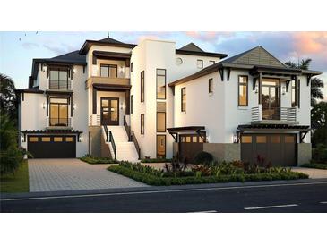 Stunning modern three-story home with a pristine white exterior and meticulously manicured landscaping at 4050 Higel Ave, Sarasota, FL 34242