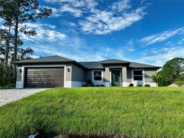 Beautiful single-story home with a neatly manicured lawn and neutral-toned exterior under a sunny sky at 5473 Gagnon Ter, North Port, FL 34291