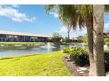 Scenic view of the condo building overlooking the lake with water fountains under a sunny sky at 5624 Ashton Lake Dr # 5624, Sarasota, FL 34231