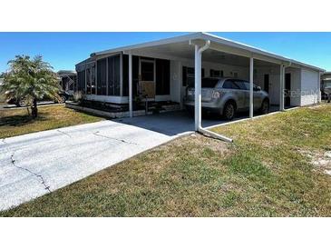 Charming single-story home with a driveway, carport, and screened lanai, surrounded by a well-maintained lawn at 606 Cyprus Ct, Bradenton, FL 34207
