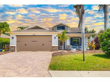 Charming home featuring a brick driveway, two-car garage, and well-manicured lawn with mature landscaping at 7209 35Th E St, Sarasota, FL 34243