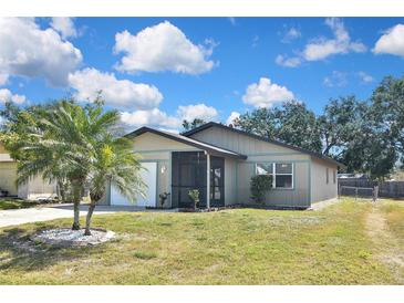 Charming single-story home featuring a screened porch, attached garage, and well-maintained lawn under a bright blue sky at 1011 Bacon Ave, Sarasota, FL 34232