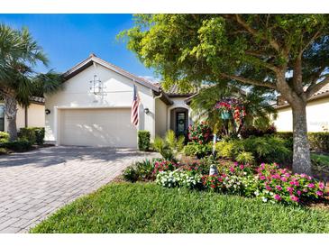 Charming home featuring a two-car garage, beautiful landscaping, and a brick-paved walkway to the front door at 2397 Vaccaro Dr, Sarasota, FL 34231