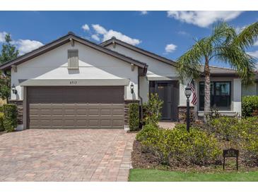 Charming single-story home featuring a brick driveway, a two-car garage, and professionally landscaped front yard at 6713 Chester Trl, Bradenton, FL 34202