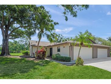 Charming home featuring a two-car garage, lush landscaping, and a well-manicured lawn at 314 Oak Hill Way # 24, Sarasota, FL 34232
