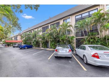Exterior view of the condo building showcasing palm trees and convenient parking at 3700 S Osprey Ave # 122, Sarasota, FL 34239