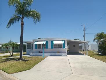 Charming home featuring a carport, blue awnings, a palm tree and a spacious driveway at 4920 Boca Raton Ave, Sarasota, FL 34234
