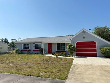 Charming single Gathering home with a red front door and a driveway leading to a garage at 5315 Malamin Rd, North Port, FL 34287