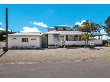 Charming single-Gathering home features white exterior, metal roof, and inviting front porch, near the beach at 601 Gulf S Dr, Bradenton Beach, FL 34217