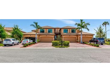 A beautiful two-story home featuring well-maintained landscaping, brick paved driveways, and attached two car garages at 6406 Grand Estuary Trl # 102, Bradenton, FL 34212