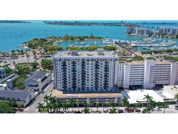 Stunning aerial view of the waterfront condominium building with boat docks and open ocean in the background at 101 S Gulfstream Ave # 5J, Sarasota, FL 34236