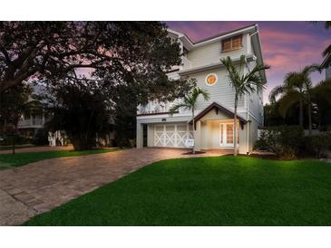 Charming two-story home with well-maintained landscaping, brick driveway, and a two-car garage at 113 Maple Ave, Anna Maria, FL 34216