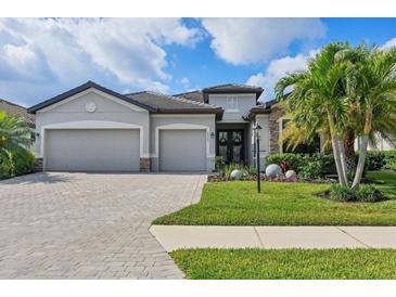 Beautiful single-Gathering home with a well-manicured lawn, stone accents, and a three-car garage at 18045 Polo Trail St, Bradenton, FL 34211