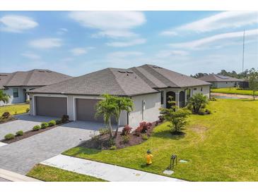 Beautiful single-story home with a well-manicured lawn and a two-car garage in a sunny location at 2072 Mackerel St, Port Charlotte, FL 33953