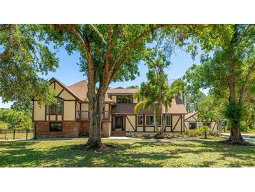 Charming two-story home with a well-manicured lawn and mature trees in a serene outdoor setting at 222 High Point Dr, Venice, FL 34292