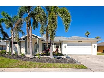 Charming single Gathering home featuring a two-car garage, lush landscaping, and curb appeal at 4092 Green Tree Ave, Sarasota, FL 34233