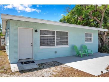 Charming single-story home with a light blue exterior, white trim, and a cozy front entrance with green chairs at 5214 11Th S Ave, Gulfport, FL 33707