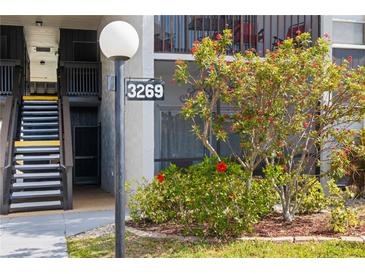 Exterior view of property featuring well-kept landscaping and stairs leading to unit at 3269 Beneva Rd # 102, Sarasota, FL 34232