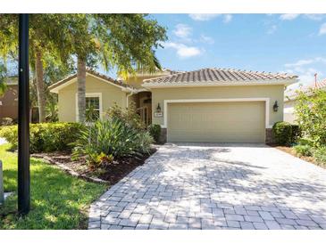 Charming home featuring a tile roof, two car garage, paved driveway and lush landscaping at 2239 Ellarose Cir, Sarasota, FL 34232