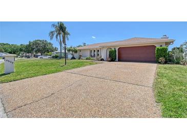 Charming single-story home with a well-manicured lawn and a spacious driveway leading to a two-car garage at 4609 Talbot Pl, Sarasota, FL 34241