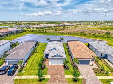 Aerial view of charming single-Gathering homes with beautiful landscaping and lake views in a desirable community at 6252 Winding Pine Dr, Nokomis, FL 34275