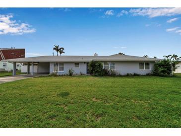Charming single-story home with a well-maintained lawn and covered parking at 6422 Beechwood Ave, Sarasota, FL 34231