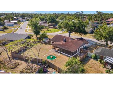 Aerial view of backyard with screened-in porch, fenced yard, and green fire pit at 6547 Samoa Dr, Sarasota, FL 34241