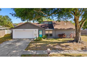 Charming single-story home featuring an attached garage, mature tree, tidy lawn, and a walkway to the front door at 6547 Samoa Dr, Sarasota, FL 34241