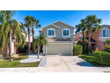 Charming two-story home boasts a well-manicured lawn and beautiful palm trees, creating a welcoming curb appeal at 7168 Chatum Light Run, Bradenton, FL 34212