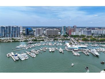 Stunning aerial view of a waterfront condo building and a marina filled with boats at 1255 N Gulfstream Ave # 402, Sarasota, FL 34236