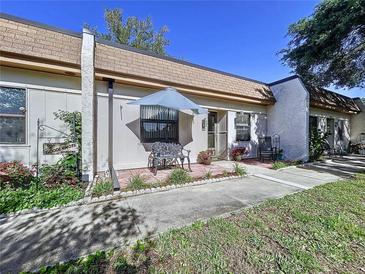 Charming villa with a quaint front patio, complete with seating and a lovely garden area, set on a sunny day at 1526 Mission Hills Blvd # 18B, Clearwater, FL 33759