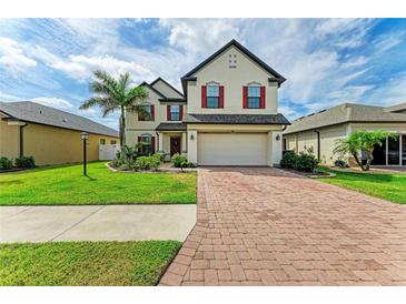 Charming two-story home with brick driveway, well-manicured lawn, and vibrant landscaping at 2084 La Palma Ave, Port Charlotte, FL 33953