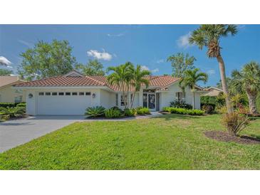 Charming single-story home featuring a red tile roof, lush landscaping, and a well-manicured lawn at 2115 Timucua Trl, Nokomis, FL 34275