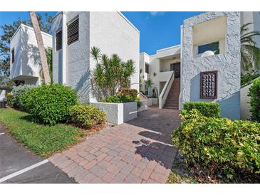Well maintained building exterior featuring clean stucco, brick entryway, and lush landscaping at 5122 Marsh Field Rd # 62, Sarasota, FL 34235