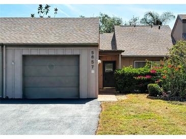 Charming townhome featuring an attached garage, well-maintained landscaping, and inviting front entrance at 5657 Westwind Ln, Sarasota, FL 34231