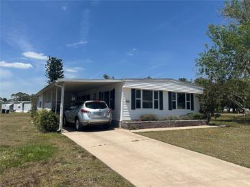 Charming single-story home with a covered parking area and well-maintained landscaping at 6882 Holo Ct, North Port, FL 34287