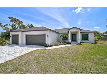 Charming single-Gathering home featuring a two-car garage, well-manicured lawn, and neutral tones at 7116 Quarry St, Englewood, FL 34224