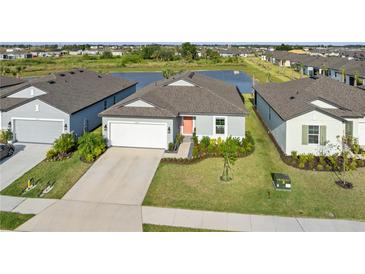 Charming single-Gathering home with a well-manicured lawn, lush landscaping, a two-car garage, and a pond view at 9725 Last Light Gln, Parrish, FL 34219