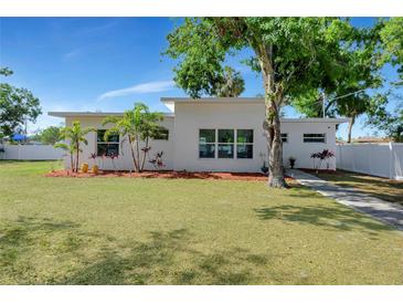 Modern home boasts a well-manicured lawn, elegant landscaping, and a white exterior with expansive windows at 3090 6Th St, Sarasota, FL 34237