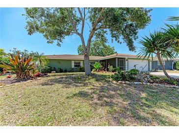 Charming single-story home featuring beautiful landscaping and a large shade tree in a well-maintained front yard at 3336 Pembrook Dr, Sarasota, FL 34239
